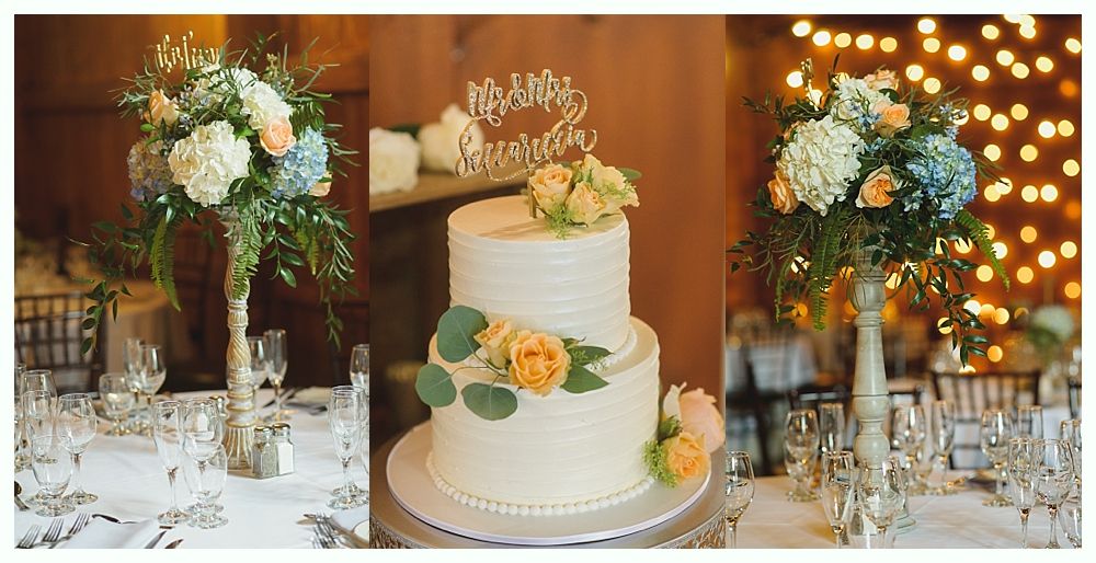 Wedding reception: two floral centerpieces flank a two-tiered cake with a 
