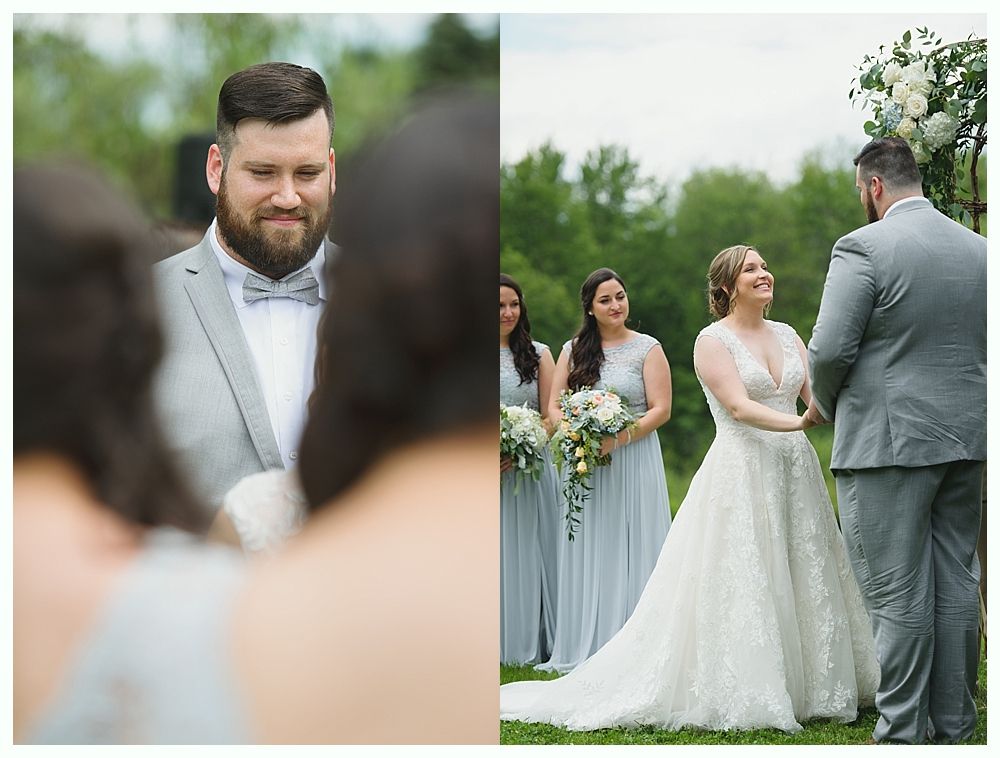 Wedding ceremony: Groom smiles at bride, who laughs. Bridesmaids in blue. Outdoor setting.