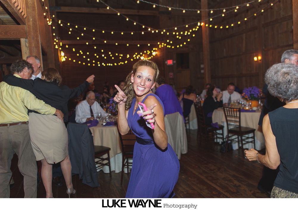 Wedding reception with dancing; bride in a white gown and guests in colorful dresses on a dance floor.