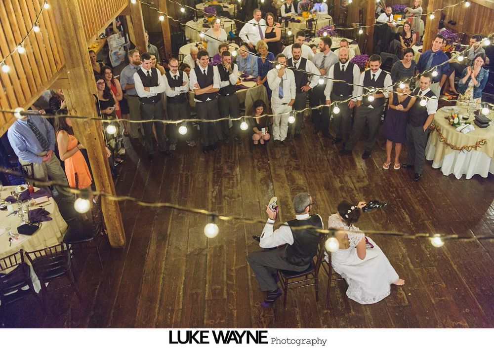Wedding reception with dancing; bride in a white gown and guests in colorful dresses on a dance floor.