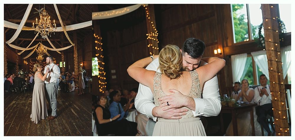 Bride and groom dancing in a barn during their wedding reception. Guests in the background. Warm, inviting atmosphere.