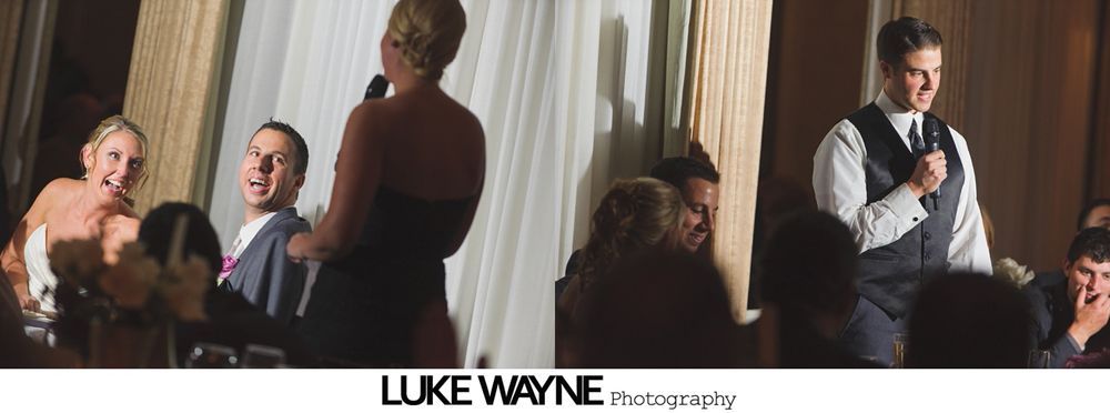 People at a wedding reception, listening to toasts. A man speaks into a microphone.