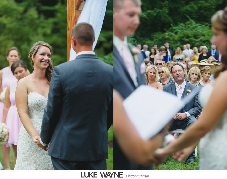 Wedding ceremony, bride and groom holding hands, surrounded by guests in a natural setting.