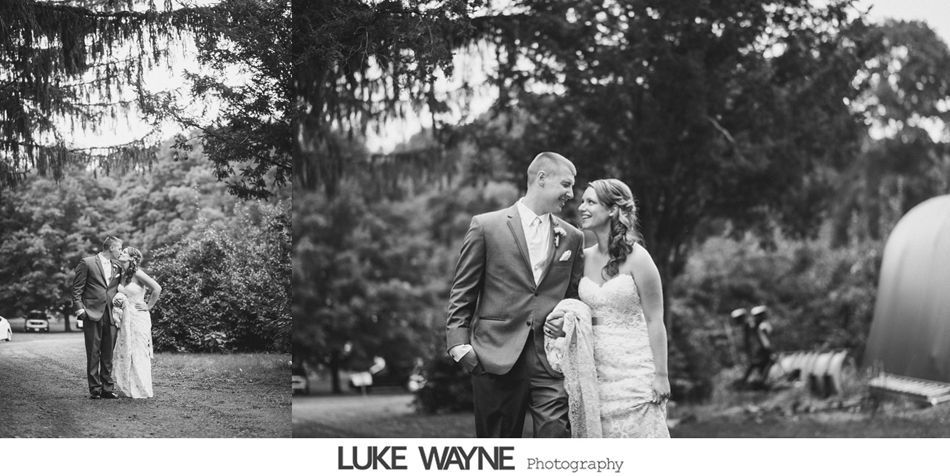 Newlyweds gaze at each other in a park-like setting, trees in the background. Black and white photograph.