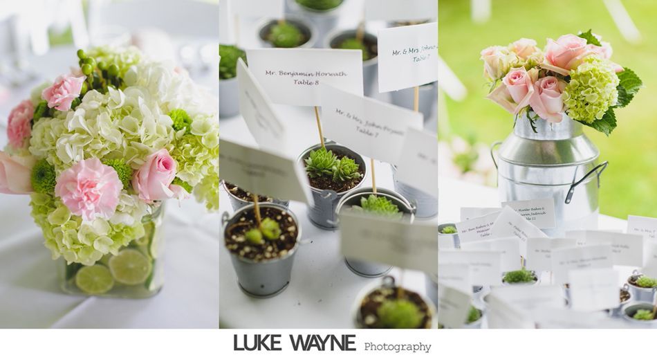 Wedding table decorations with flowers, place cards, and small potted plants.