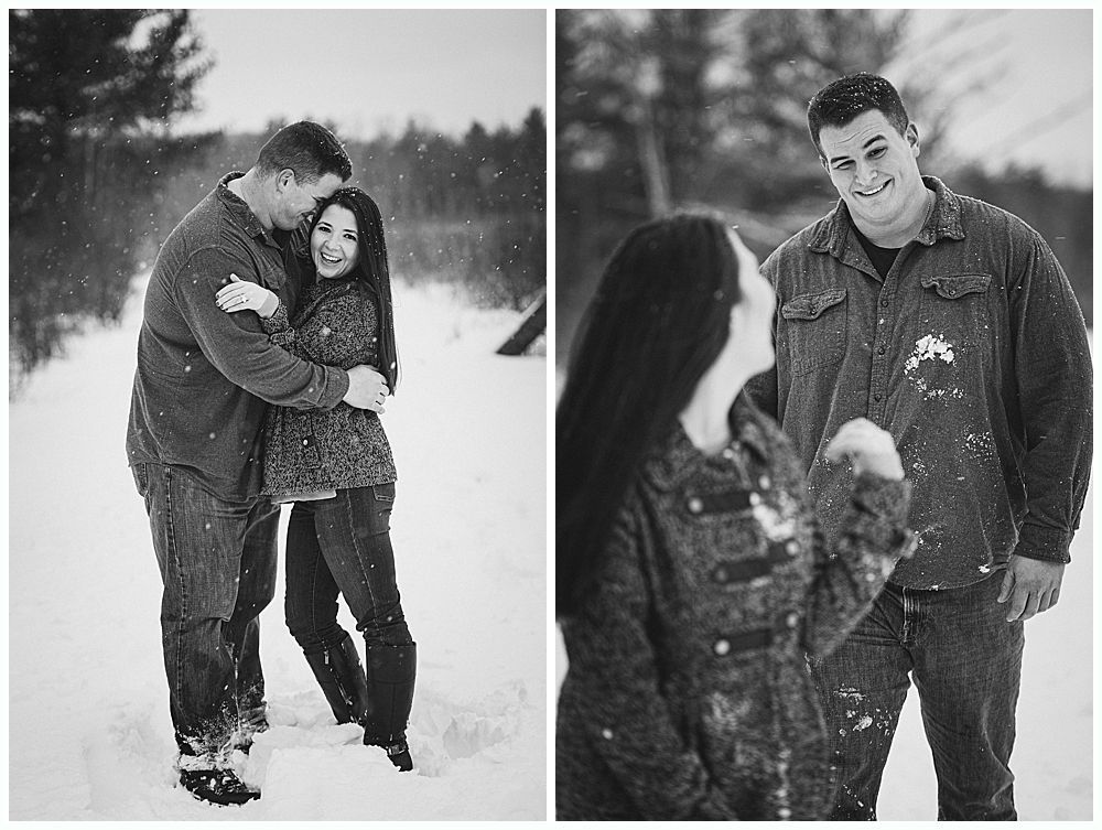 Couple embracing in a snowy field. Man smiles at woman as they enjoy a winter moment. Black and white.