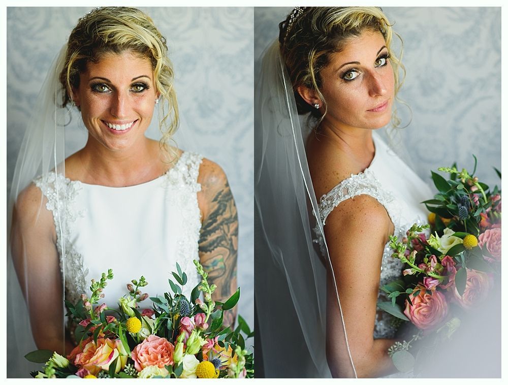 Bride holding bouquet, smiling, wearing white dress with lace, veil, floral crown.