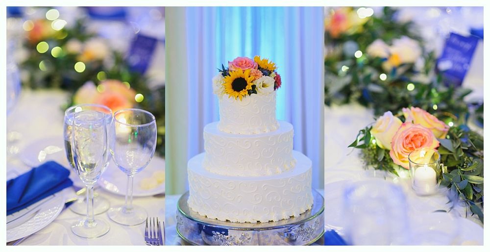 Wedding cake centerpiece with flowers; table setting with blue napkins and flowers.