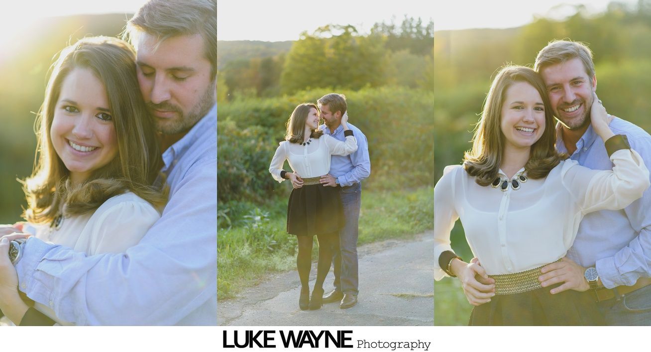 Couple sitting on a rock by the ocean, smiling and looking at each other.