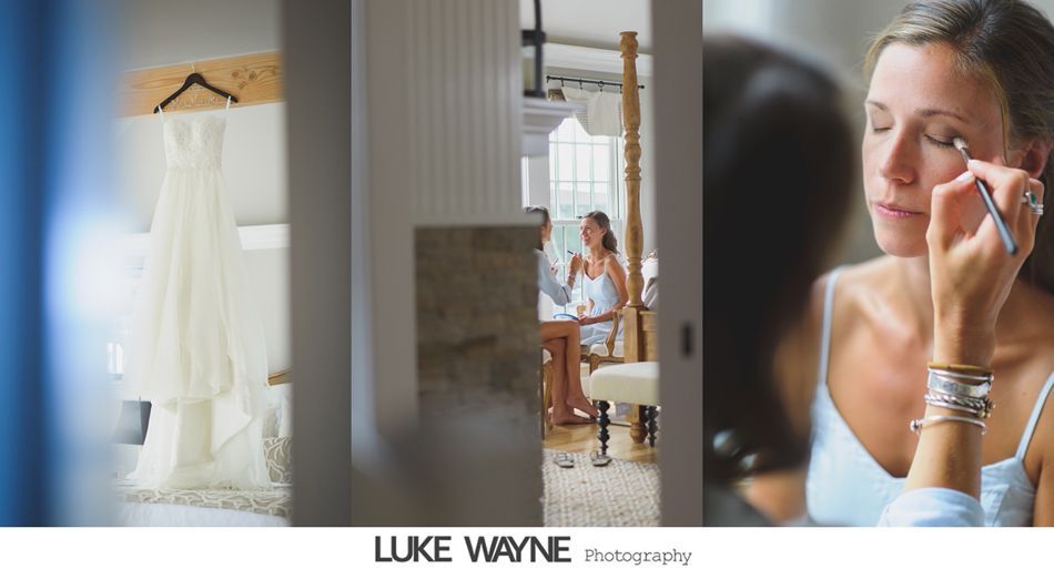 Wedding dress hanging, bride gets makeup applied, other woman in background.
