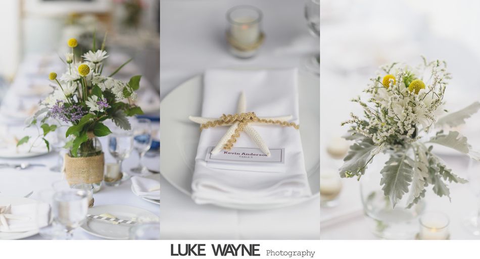 Wedding table decorations with flowers, napkins, and starfish, set on a white tablecloth.