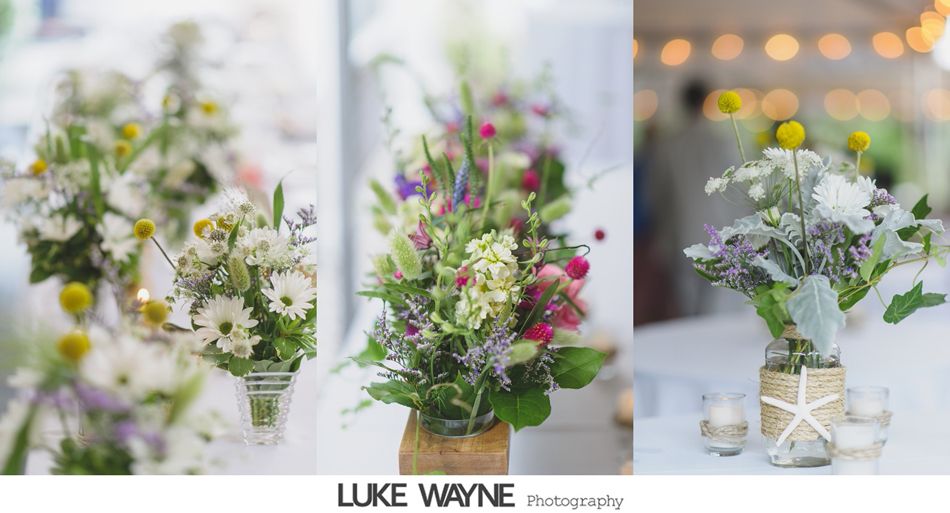 Three floral centerpieces in jars with wildflowers.