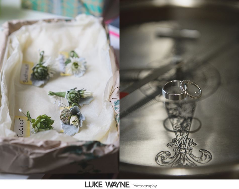 Wedding details: Boutonnieres in a box, wedding rings on a silver tray.