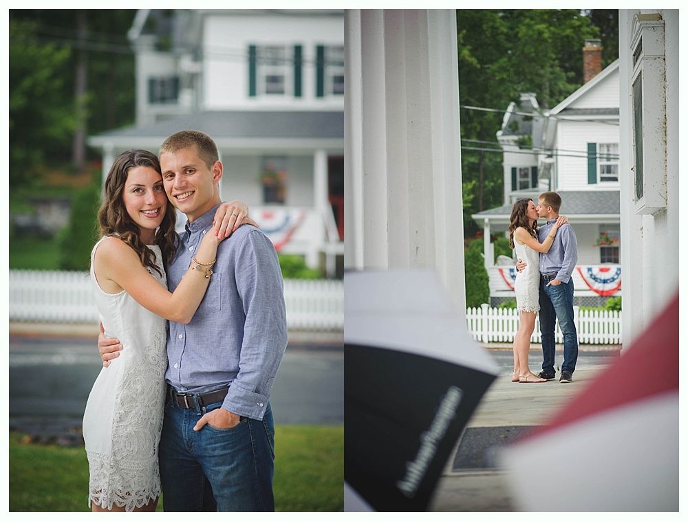 Couple on boardwalk by ocean, framed by beach plants under a blue sky with clouds.
