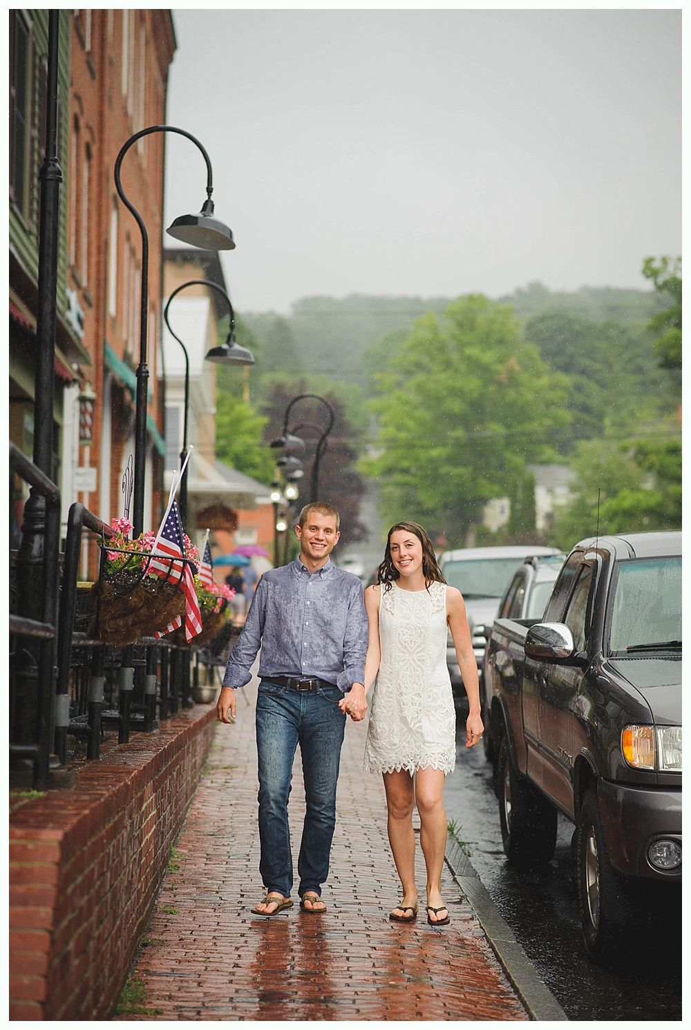 Bride with arms up, making a funny face, groom looking at his hand, cake cutting in background.