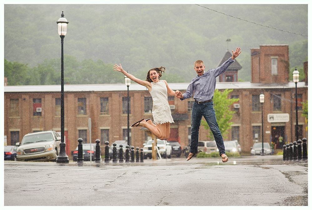 Bride with arms up, making a funny face, groom looking at his hand, cake cutting in background.