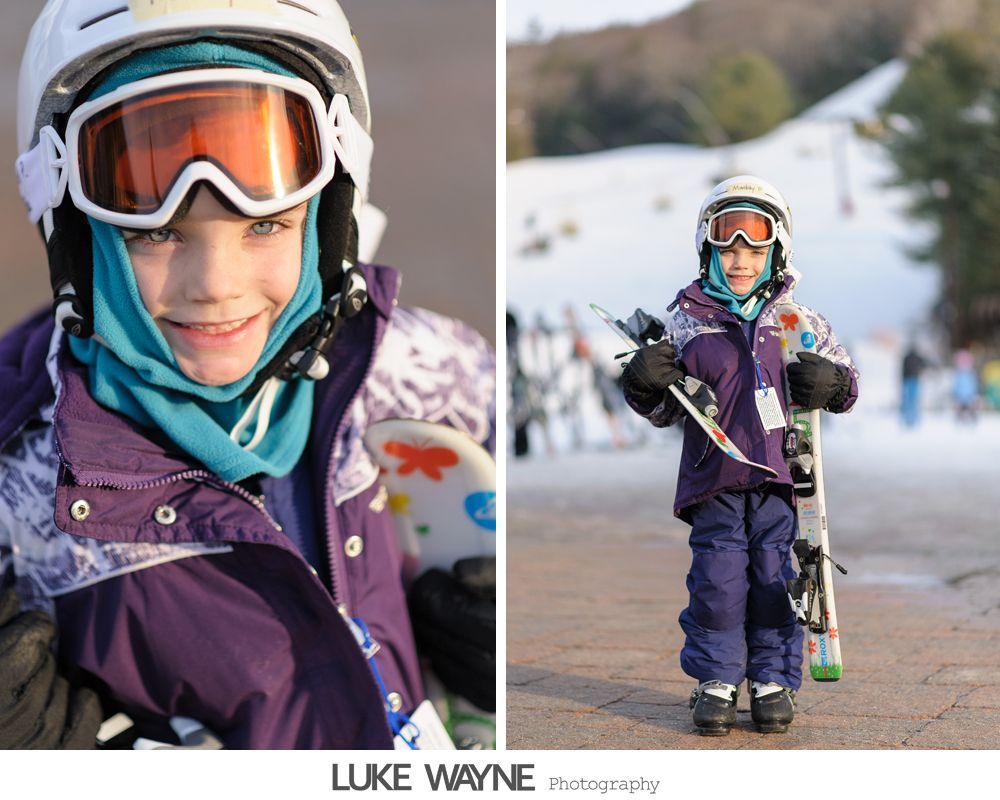Silhouetted men helping each other with suits in a bright room by a window.