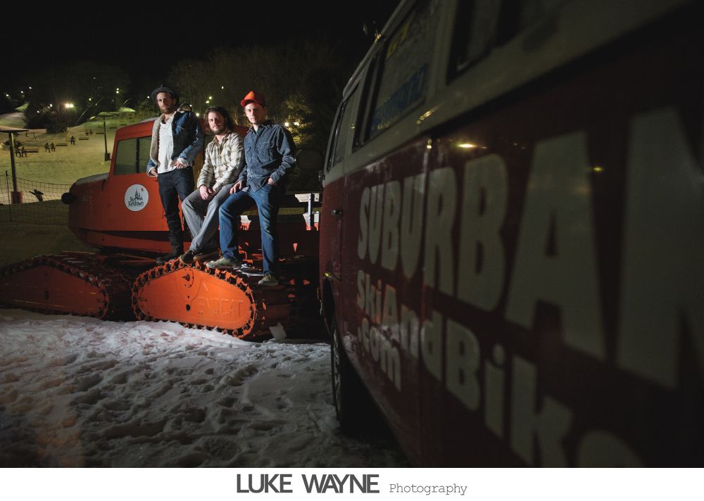 Wedding party on steps, bride in white dress, bridesmaids in purple dresses, groomsmen in gray suits.