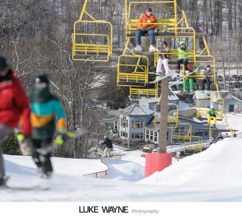 Wedding party posing in bar: bride on bar, groomsmen sprawled on floor, expressions of exhaustion.
