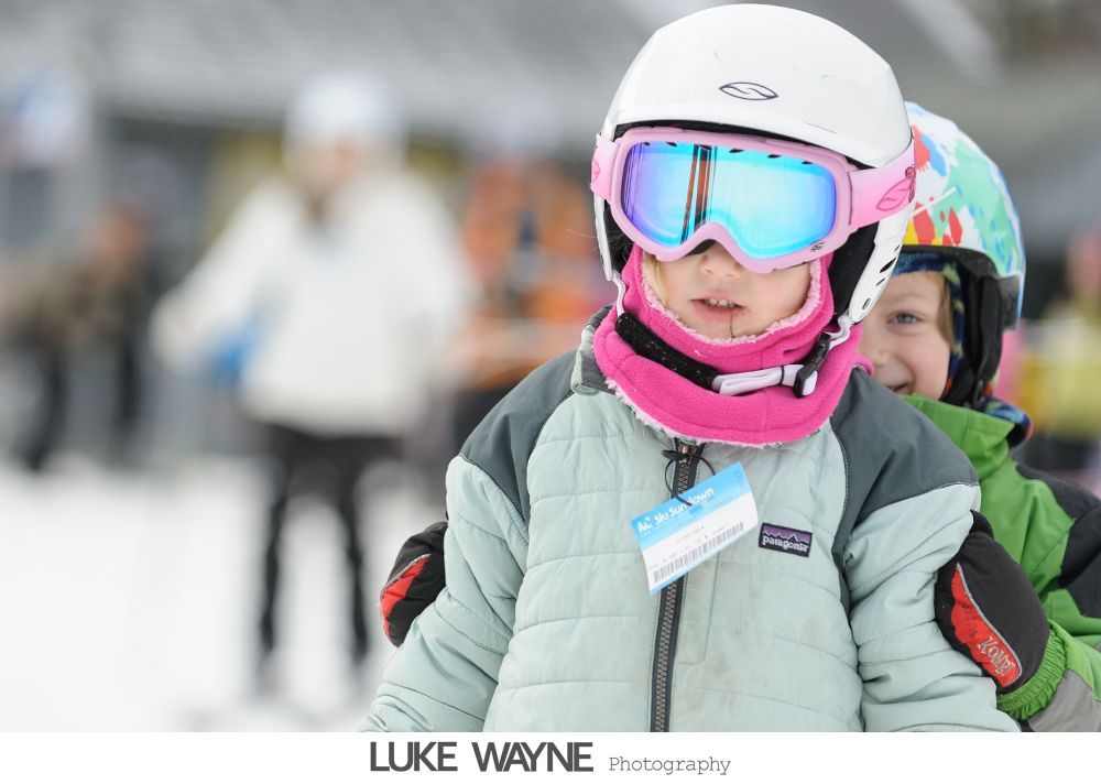 Bride and bridesmaids in purple dresses at a bar, toasting with drinks.