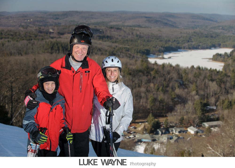 Silhouetted wedding couple and officiant in front of an arched window.