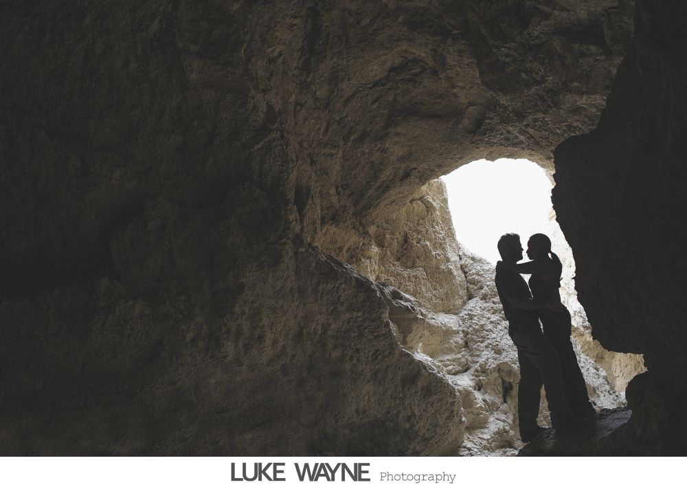 Jewelry arrangement: earrings, feather hair accessory, and a jeweled watch on a wooden surface.