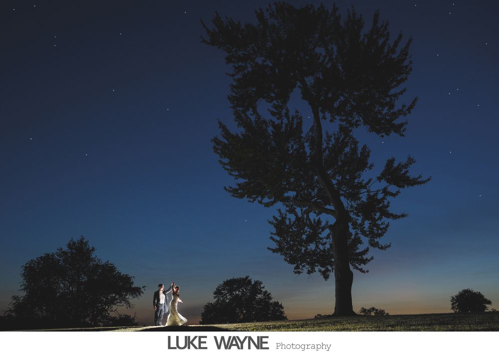Silhouette of someone applying makeup near a window, natural light.