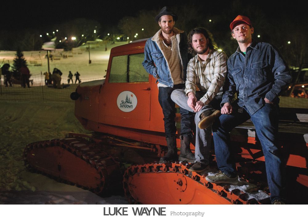 Four-panel photo of a couple at a bar. They pose with a whiskey bottle, with varying expressions: happy, playful, and drinking.