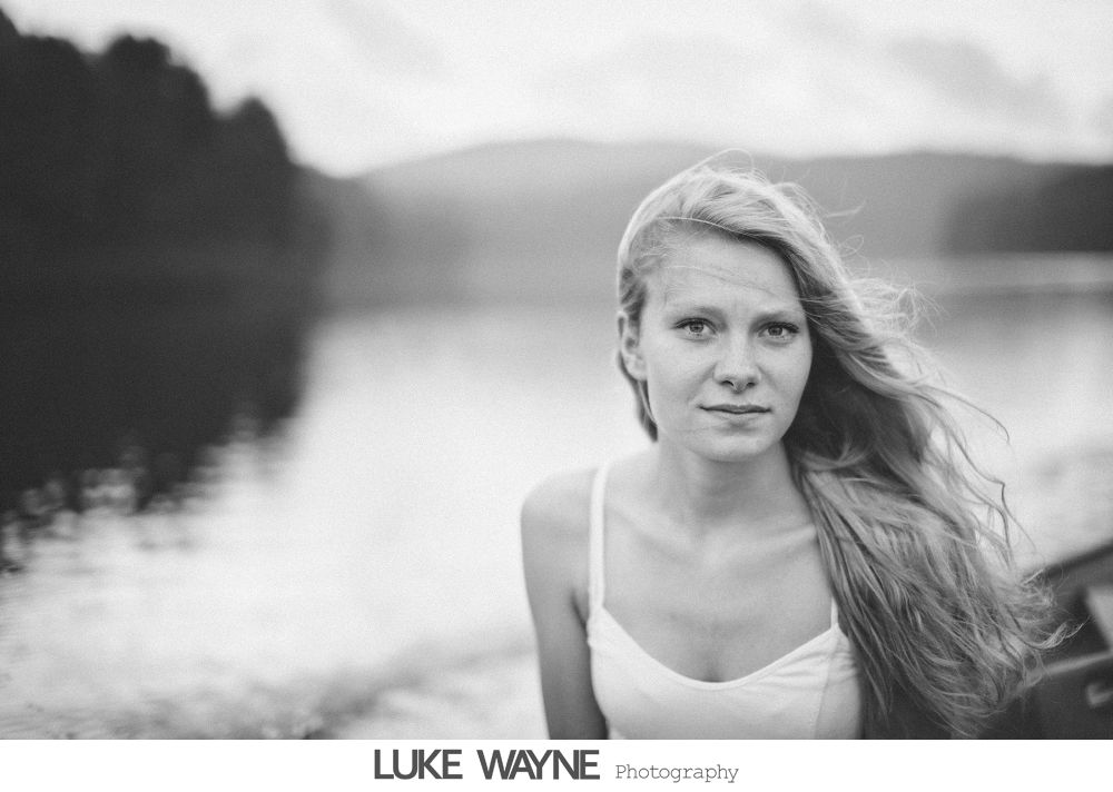 Wedding party in purple and gray outfits posing outdoors in front of city buildings.