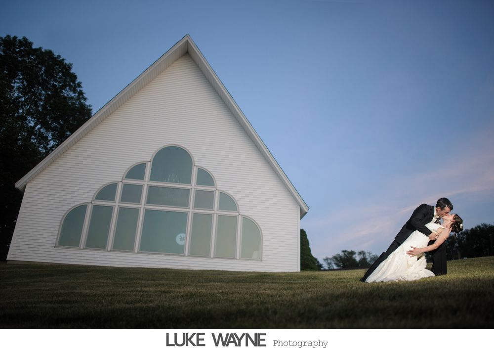 Bride and bridesmaids in purple dresses at a bar, toasting with drinks.