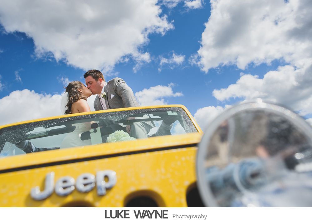 Wedding reception details: cake, flowers, wine, purple and white decor.