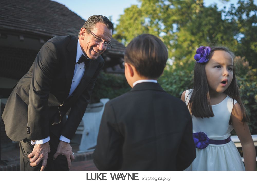 Wedding reception details: cake, flowers, wine, purple and white decor.