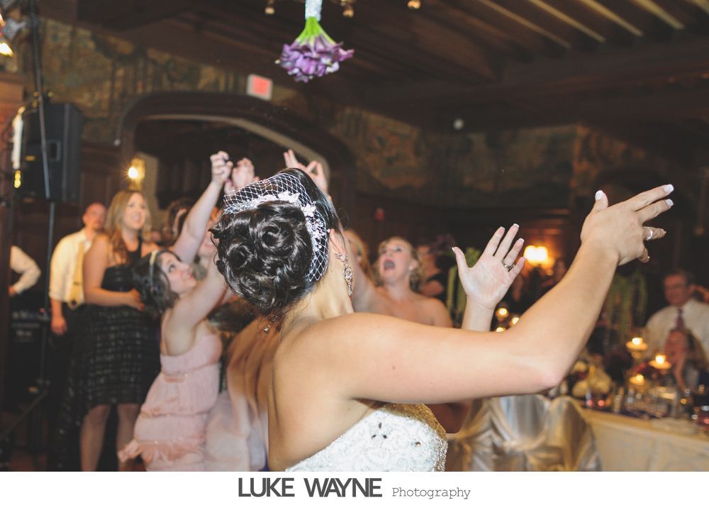 Wedding reception details: cake, flowers, wine, purple and white decor.