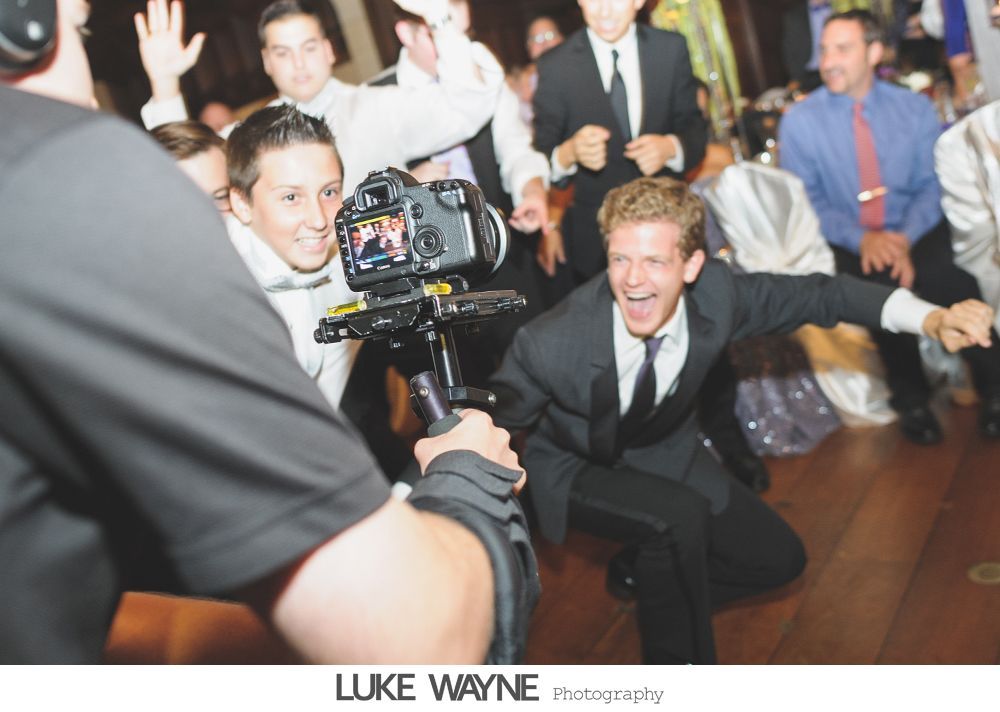 Wedding reception details: cake, flowers, wine, purple and white decor.