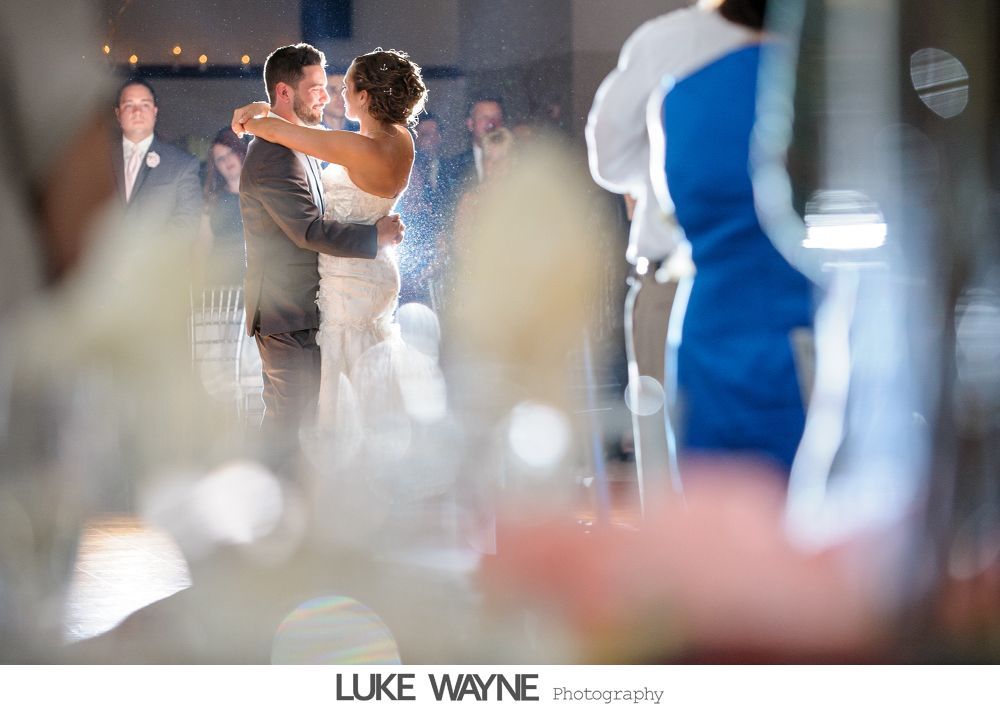 Wedding reception details: cake, flowers, wine, purple and white decor.