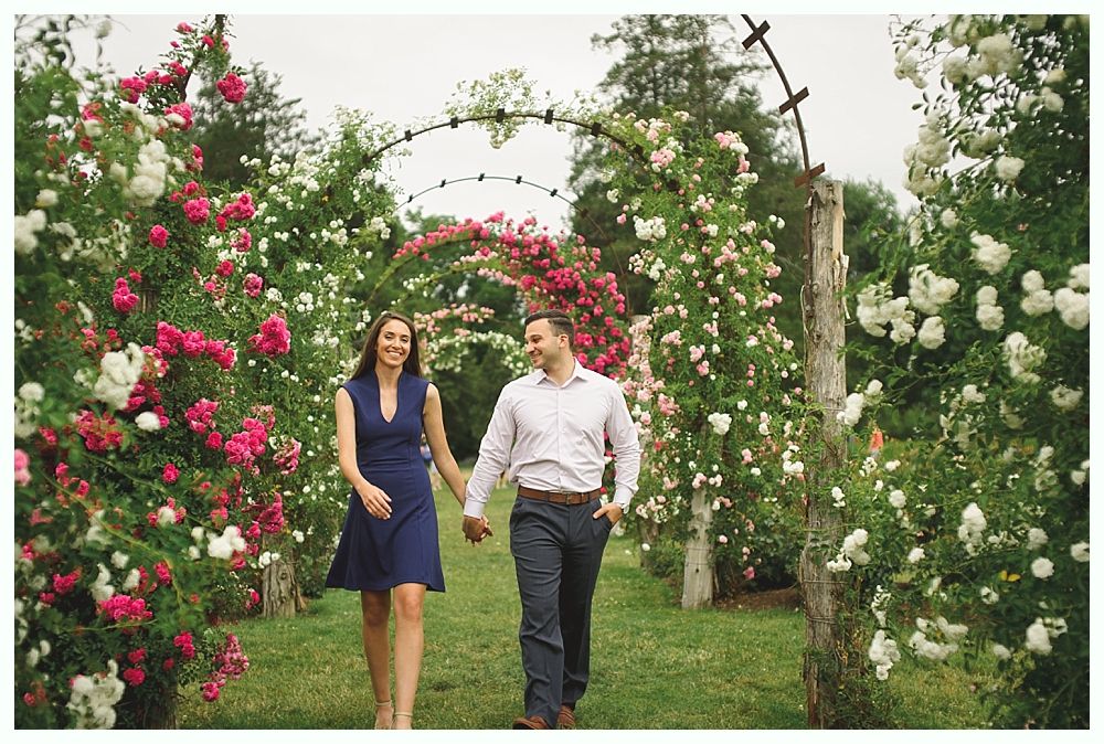 Wedding party on a metal bridge. Bride & groom, bridesmaids, groomsmen, and children smiling with bouquets.