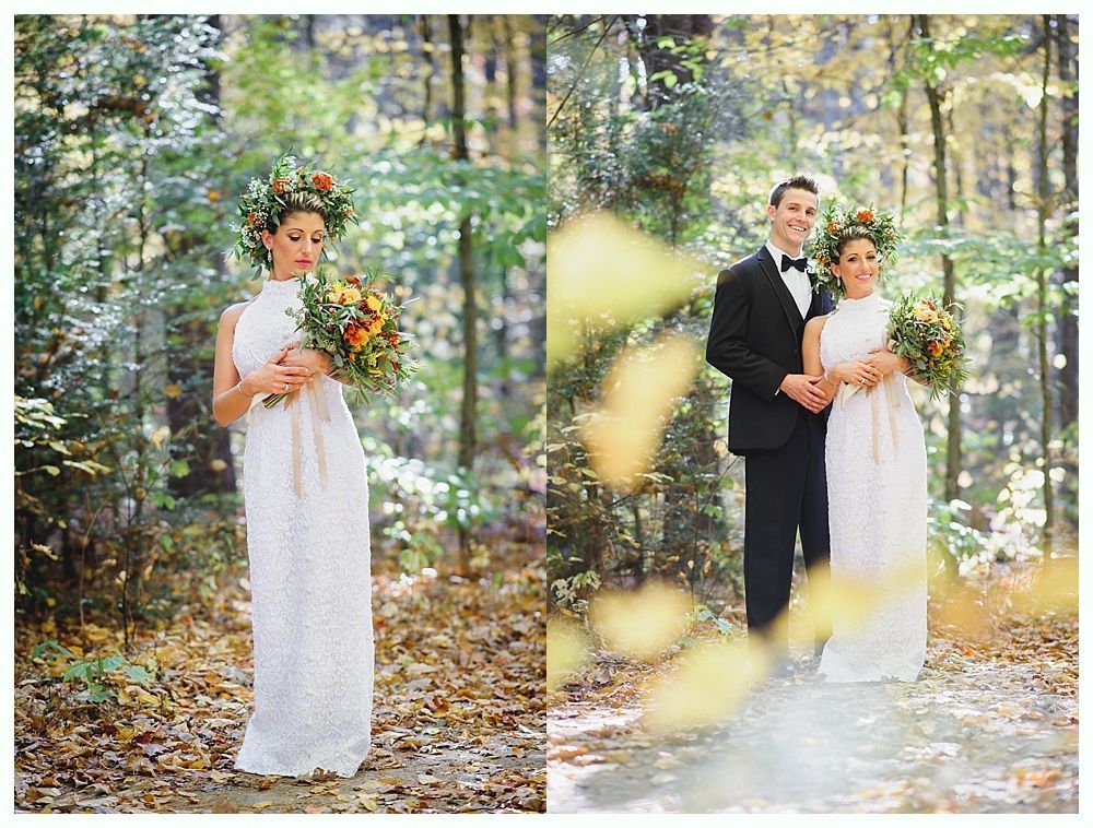 Bride in white dress, flower crown, holding bouquet, standing in a forest. Groom in tuxedo next to her.