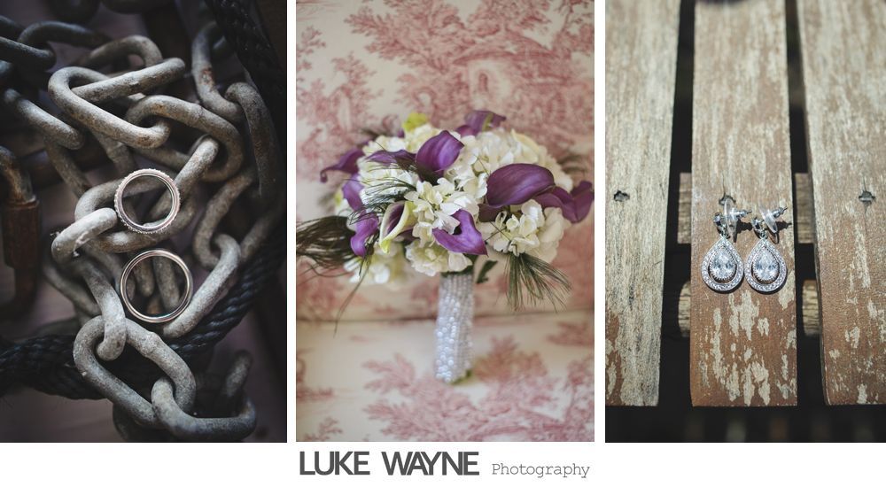 Wedding details: rings on chains, bouquet on patterned fabric, earrings on wood.