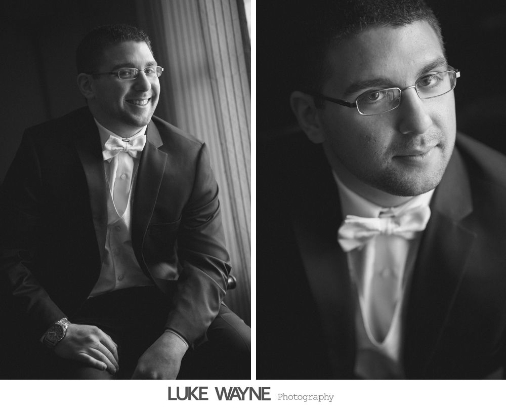Man in tuxedo and bow tie smiling and looking at the camera. Black and white.