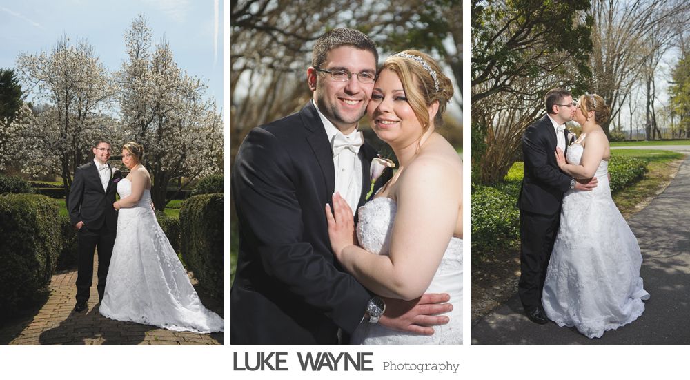 A bride and groom pose for photos outdoors. Wedding portraits with the couple smiling and embracing.