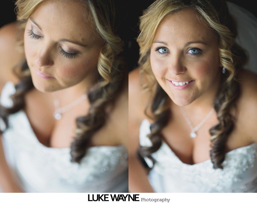 Bride holding bouquet, smiling in a room. Bridesmaids in the background.