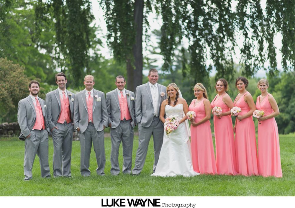 Newlyweds walking down the aisle after a wedding ceremony, guests clapping. Glass enclosed building, white paper lanterns overhead.