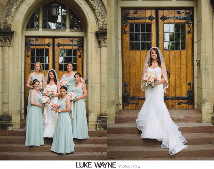 Bride and bridesmaids pose on steps in front of wooden doors. Bride wears a white dress with a veil, the bridesmaids wear light blue dresses.