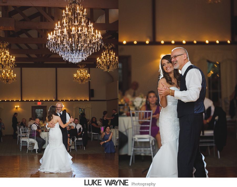 Bride dancing with her father under chandeliers at a wedding reception. Smiling, formal attire, indoor setting.