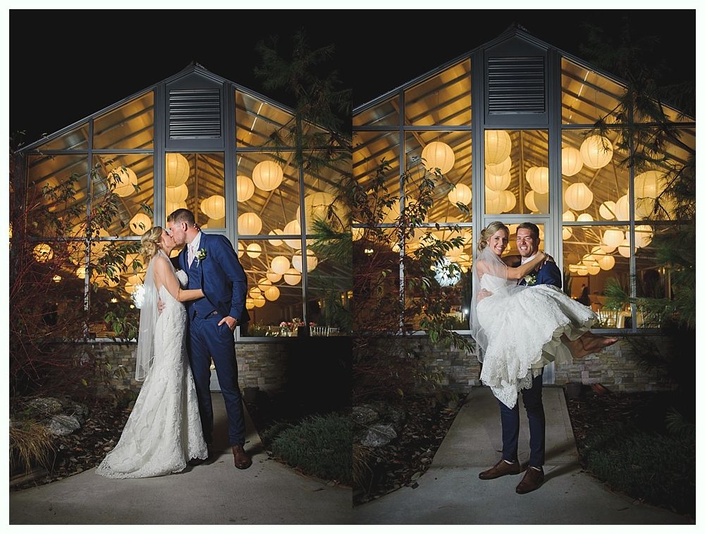 Wedding couple kissing and posing in front of a greenhouse lit with paper lanterns at night.