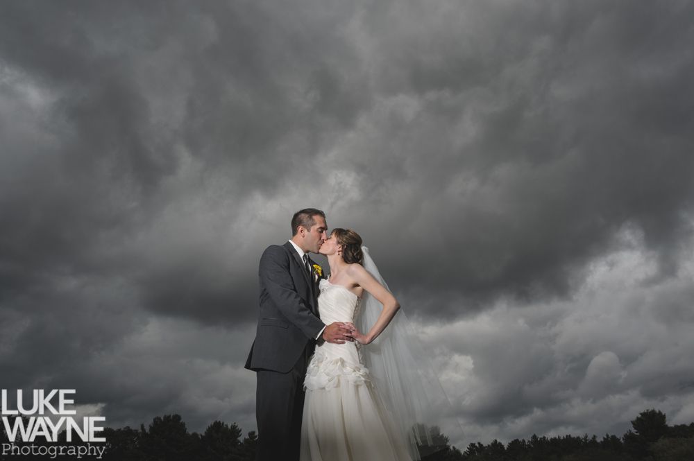 Woman smiles while gazing at man with his arm around her.