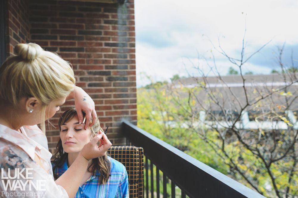 Couple embraces, overlooking a scenic valley. Woman looks toward man; both are seated. Black and white photo.
