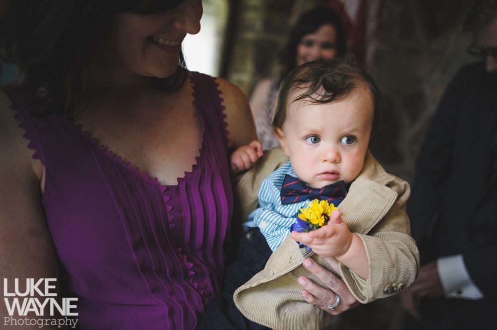 Couple holding hands, smiling; woman in denim jacket, red dress; man in light green shirt, outdoors.