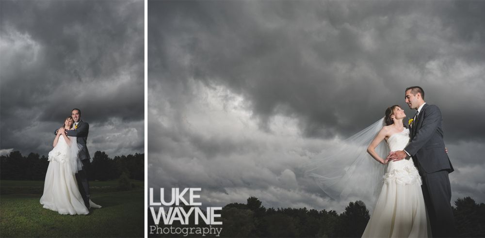 Couple embracing at sunset; man in green shirt, woman in denim jacket and red dress, with blowing hair.