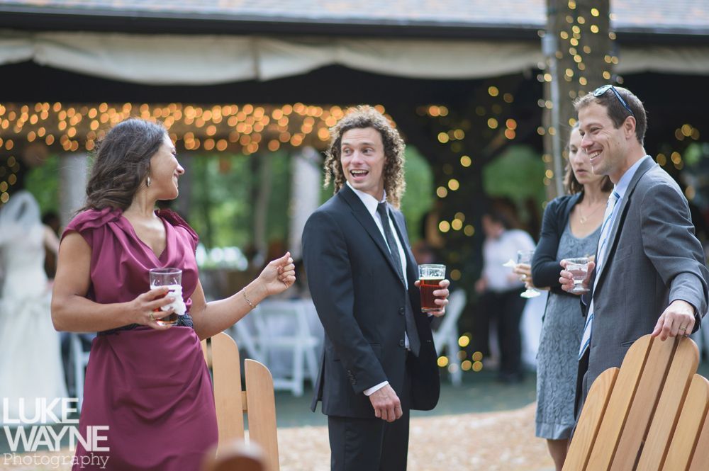 Couple embracing at sunset; man in green shirt, woman in denim jacket and red dress, with blowing hair.
